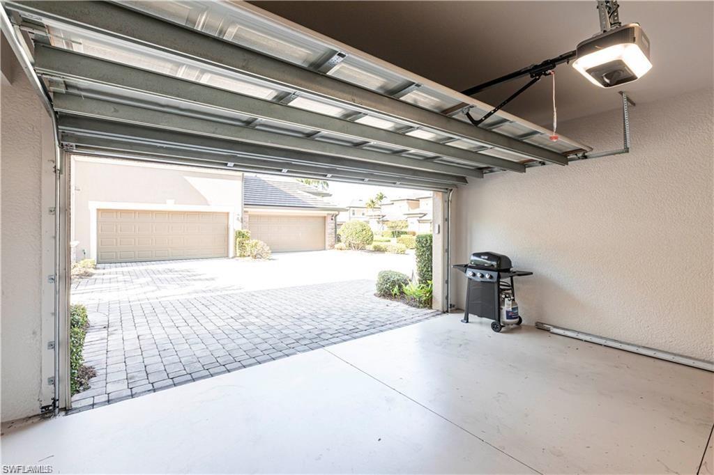 Garage featuring a textured wall and a garage door opener