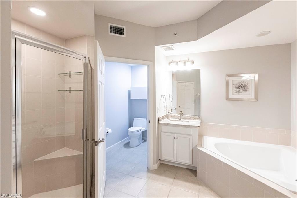 Full bathroom with vanity, light tile patterned floors, a stall shower, and a bath
