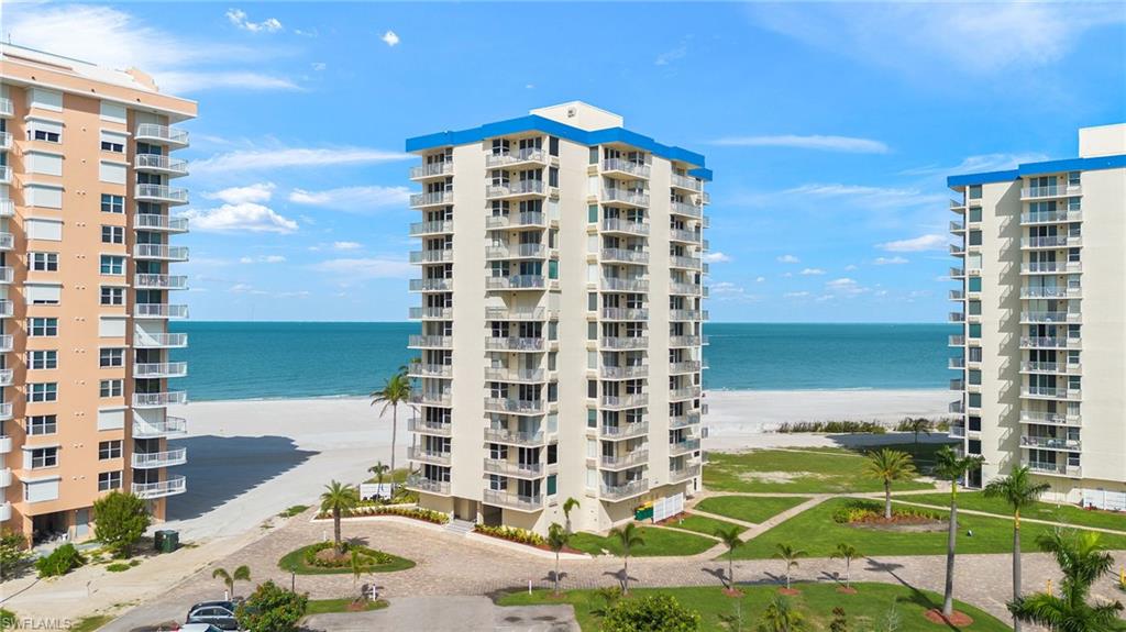 View of apartment building / complex with view of water and beach