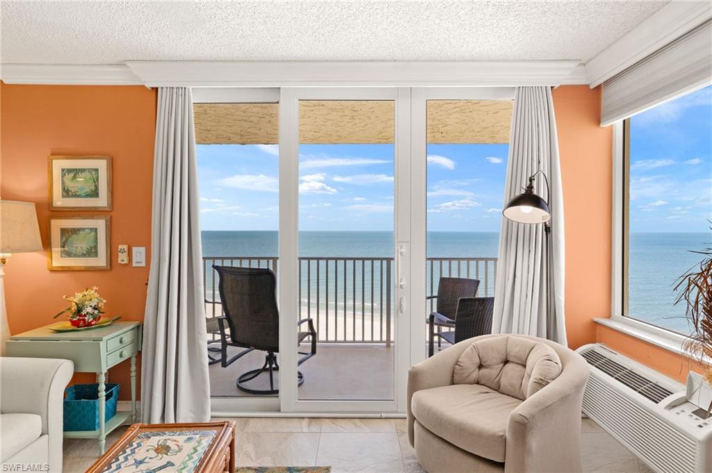 Living area featuring a water view, healthy amount of natural light, ornamental molding, and a textured ceiling