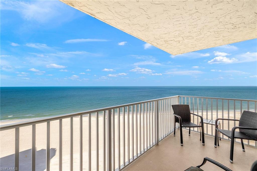 Balcony featuring view of water and beach