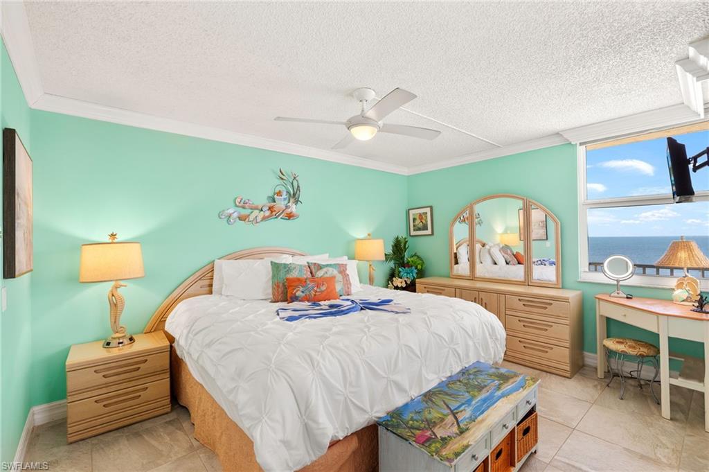 Bedroom with ornamental molding, a textured ceiling, a ceiling fan, and light tile patterned floors