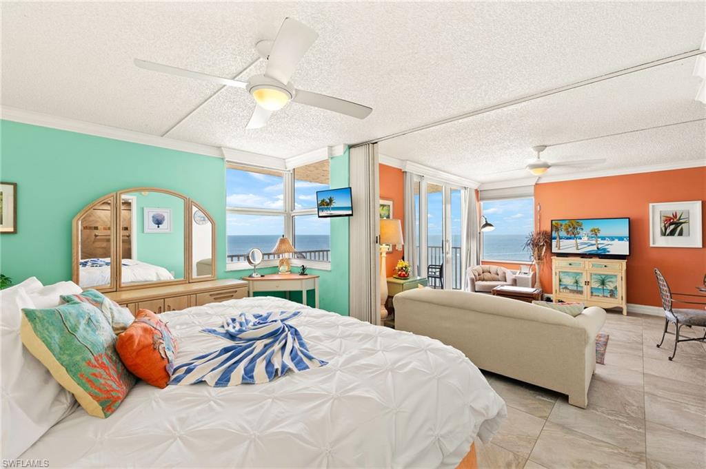 Bedroom with ornamental molding, access to outside, floor to ceiling windows, ceiling fan, and a textured ceiling