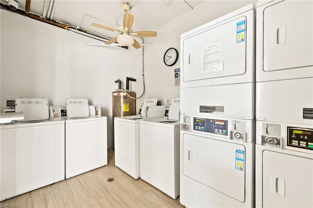 Shared laundry room featuring a ceiling fan, independent washer and dryer, and electric water heater