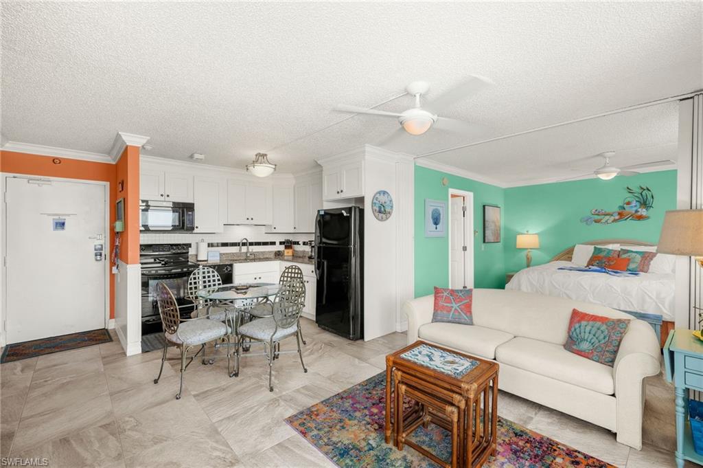 Living area featuring ornamental molding, a textured ceiling, and a ceiling fan