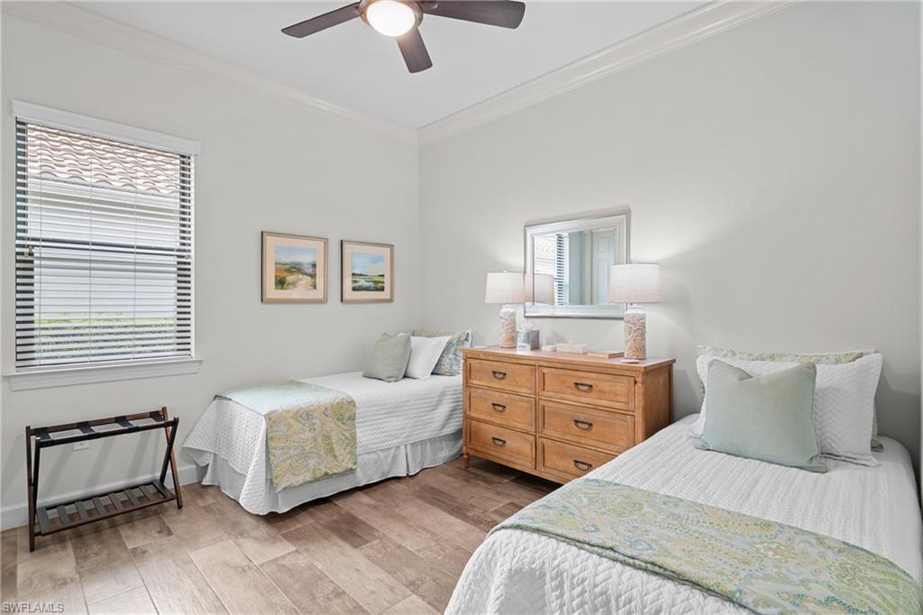 Bedroom with crown molding, light wood-type flooring, multiple windows, and ceiling fan