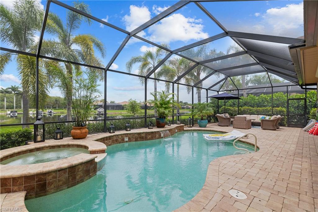 Integrated pool / spa with glass enclosure, a sunroom, a patio area, and outdoor lounge area