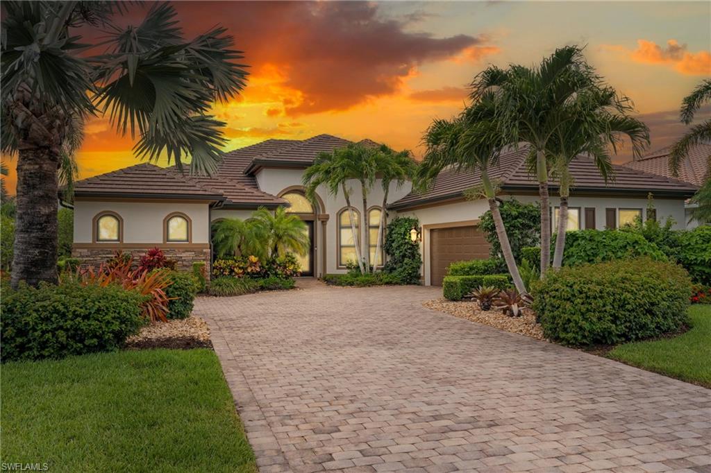 Mediterranean / spanish-style home with stucco siding, driveway, stone siding, and a garage
