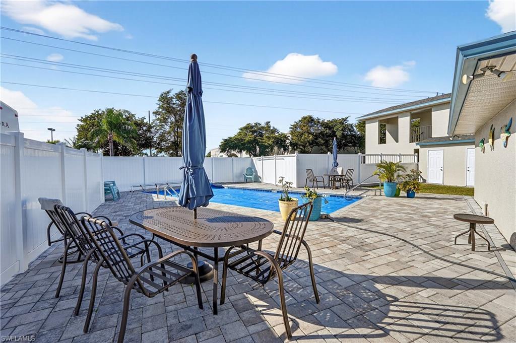 Fenced backyard with a patio area and a community pool