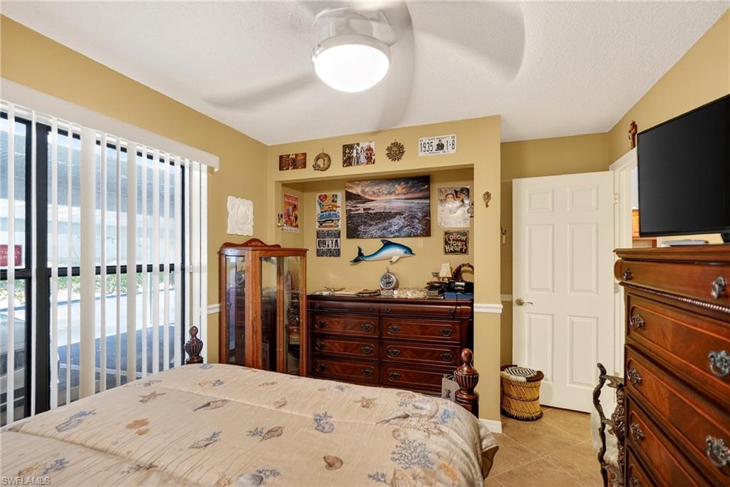 Bedroom featuring access to outside, light tile patterned flooring, and ceiling fan