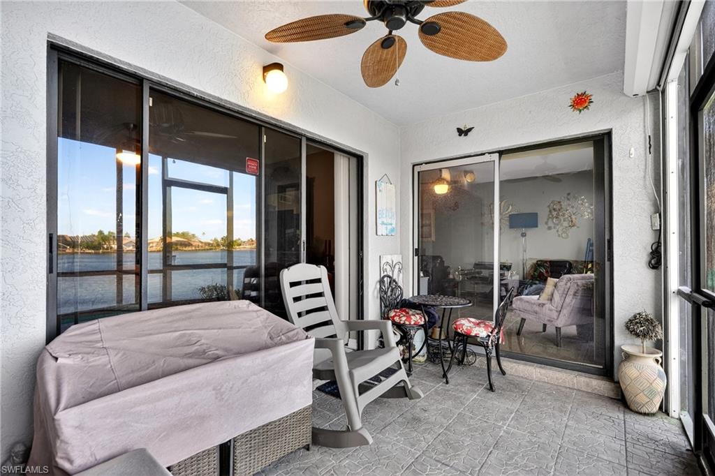View of patio with a water view and a ceiling fan