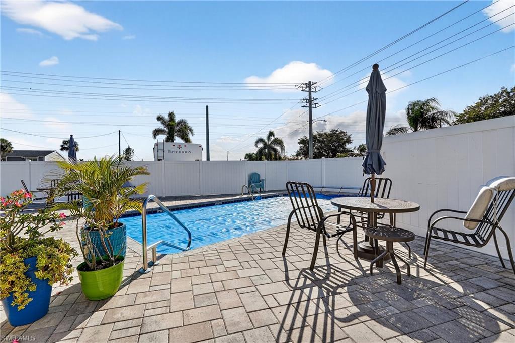 View of swimming pool featuring patio surround and a fenced backyard