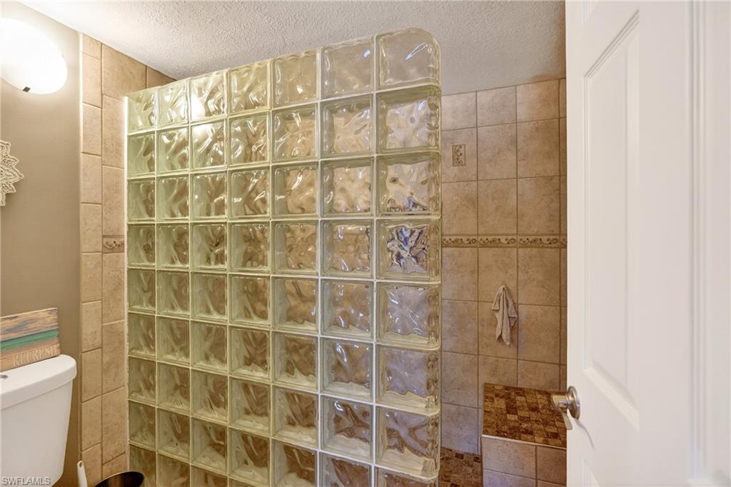 Full bath with walk in shower and a textured ceiling