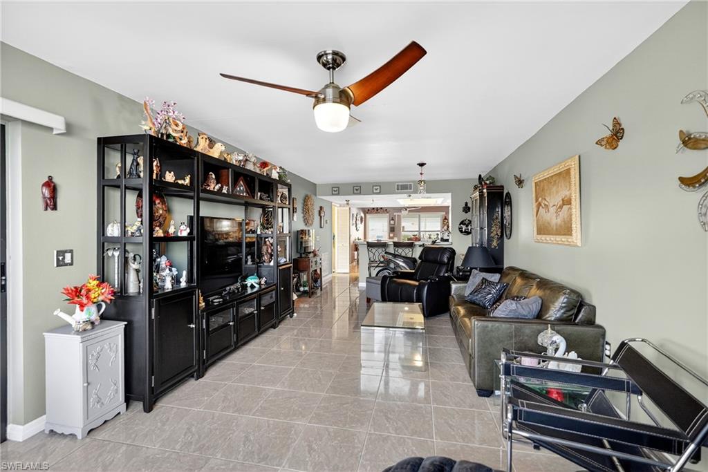 Living room with a ceiling fan and baseboards
