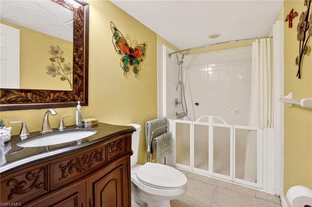 Bathroom featuring vanity, a stall shower, and light tile patterned floors