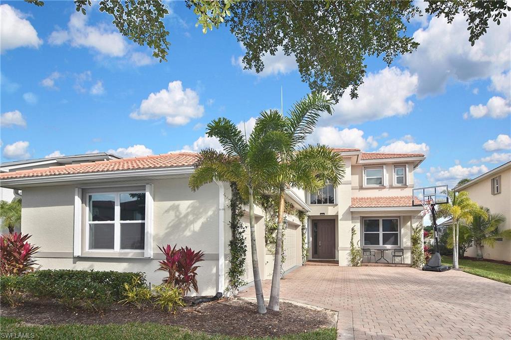 Mediterranean / spanish house with a tile roof, stucco siding, and decorative driveway