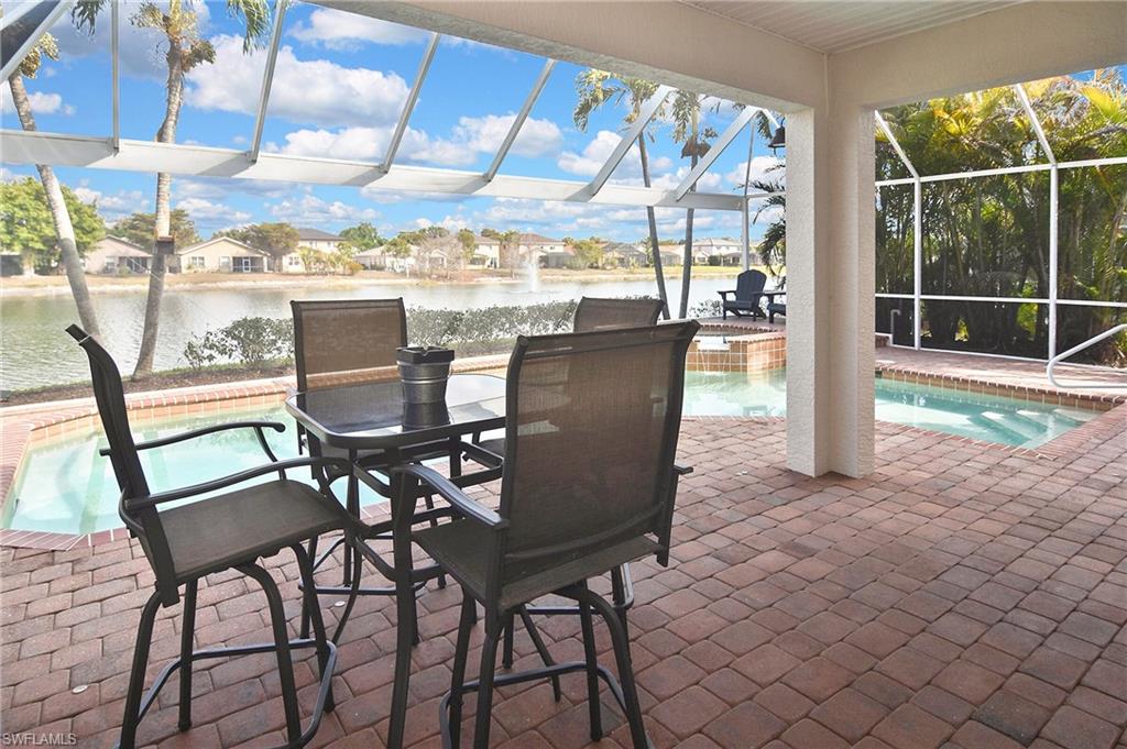 Sunroom / solarium with a patio, a residential view, a swimming pool, a jacuzzi, and a water view