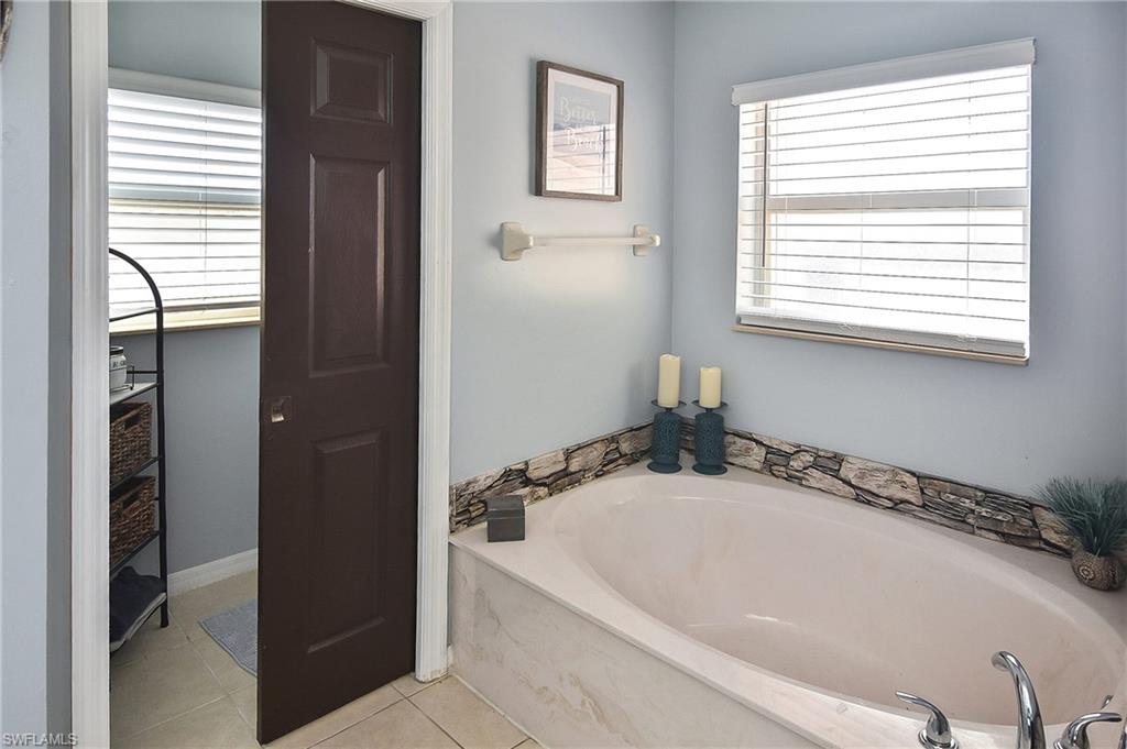 Full bathroom with a bath and light tile patterned flooring