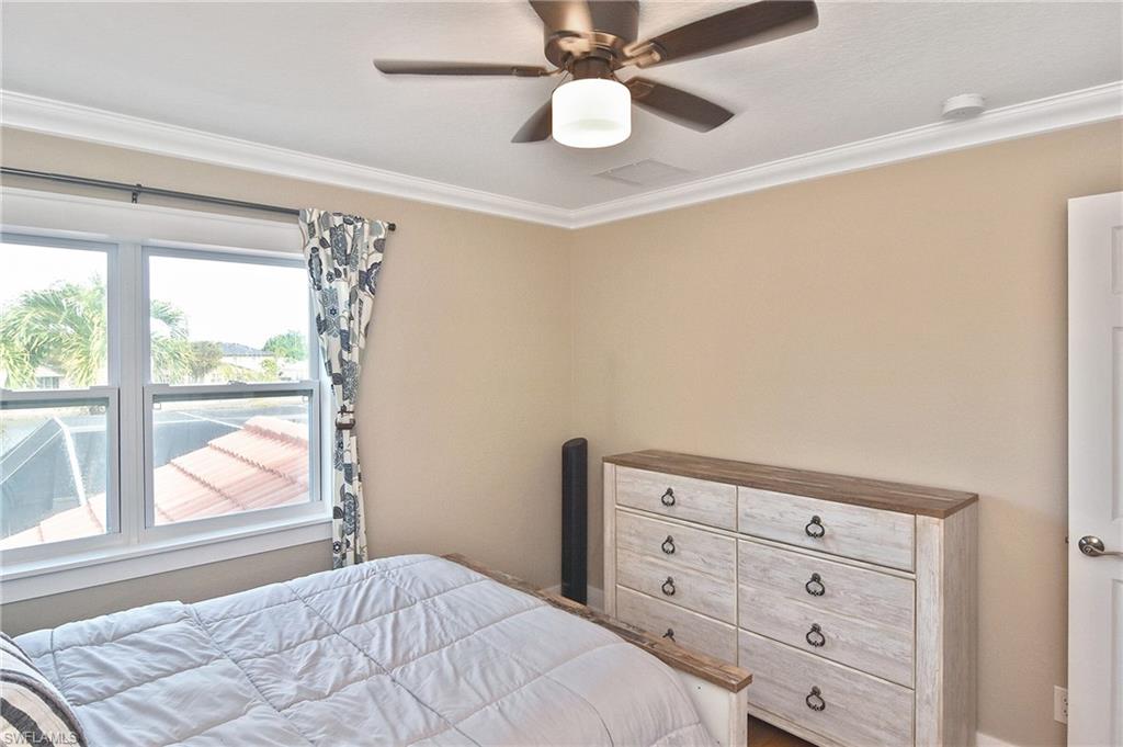 Bedroom with ceiling fan and ornamental molding