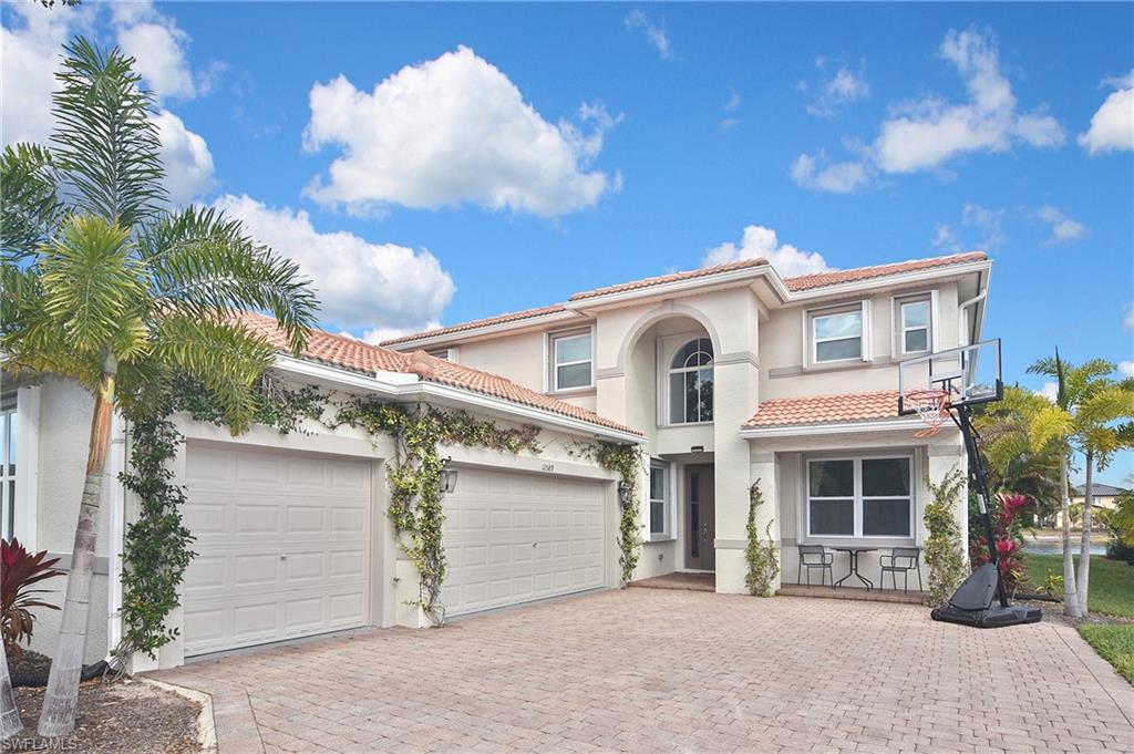 Mediterranean / spanish house with a garage, decorative driveway, stucco siding, and a tiled roof