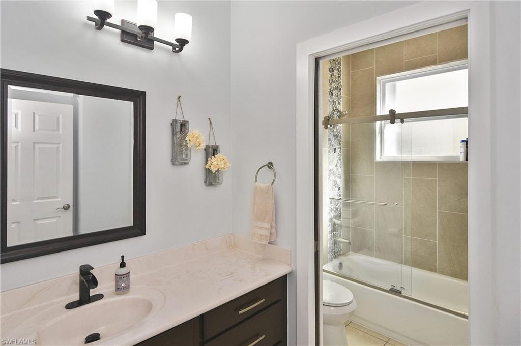 Full bath featuring vanity and enclosed tub / shower combo