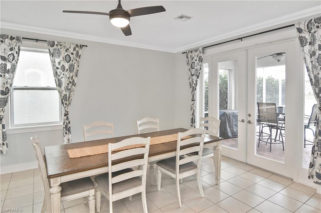 Dining space featuring french doors, crown molding, plenty of natural light, light tile patterned floors, and ceiling fan