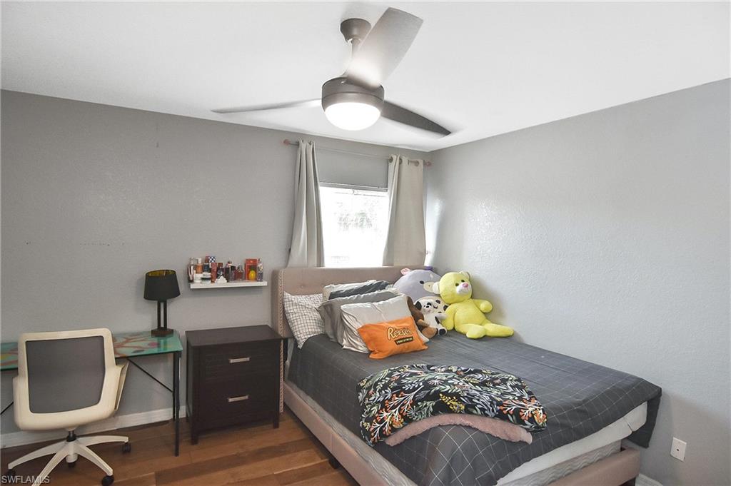 Bedroom featuring dark wood finished floors, ceiling fan, and a desk