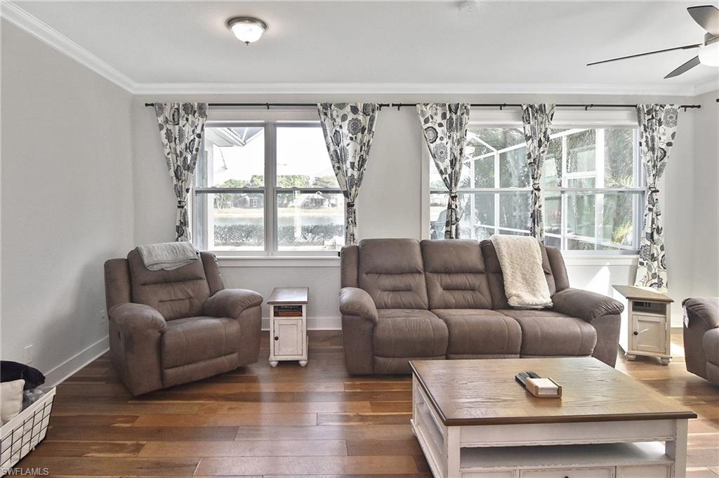 Living area featuring ornamental molding, hardwood / wood-style floors, and a ceiling fan