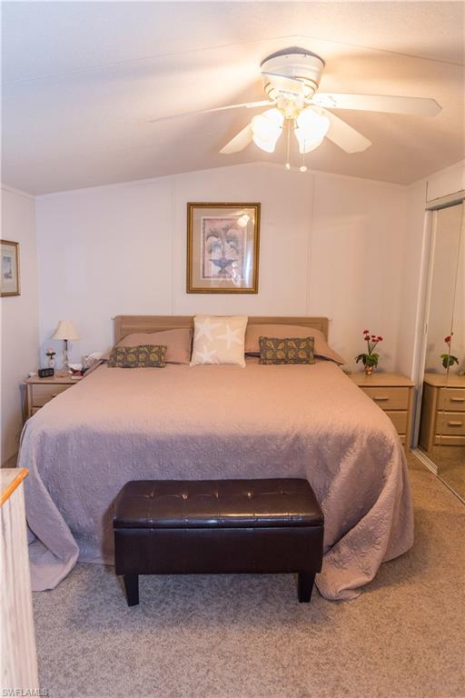 Carpeted bedroom featuring ceiling fan and a closet