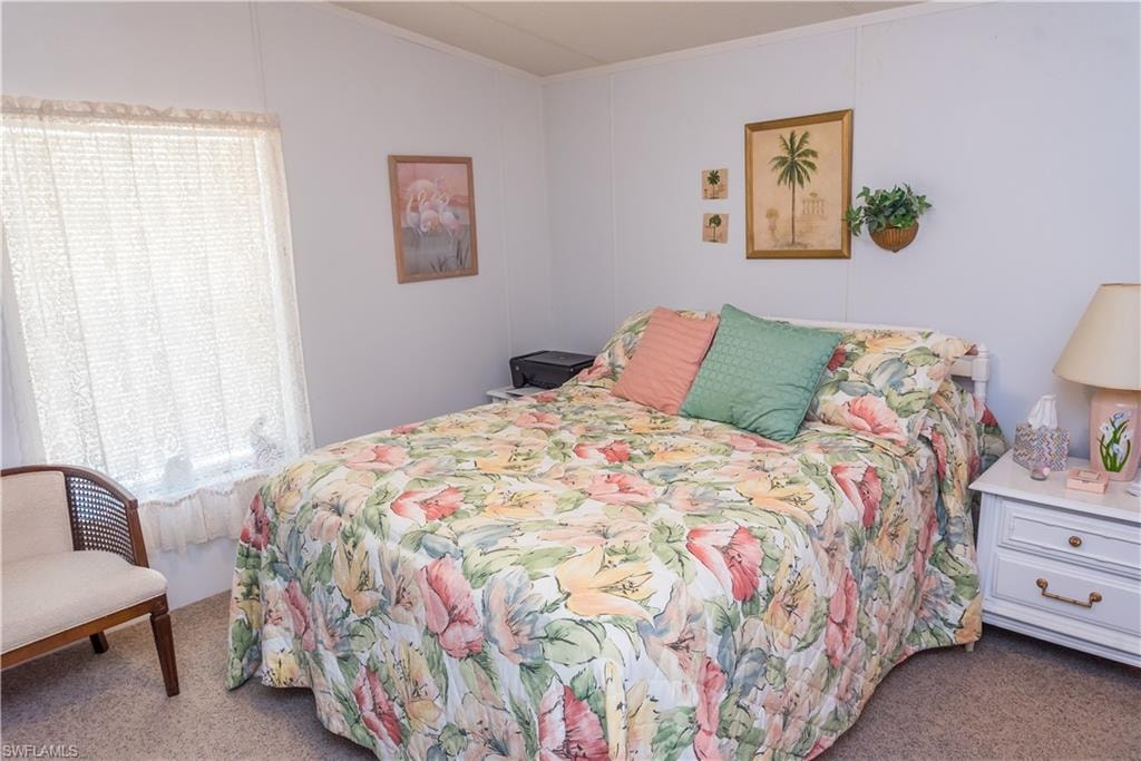 Bedroom with dark colored carpet and crown molding