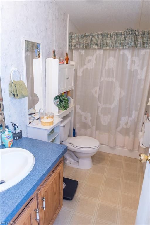 Bathroom featuring vanity, shower / tub combo, and a textured ceiling