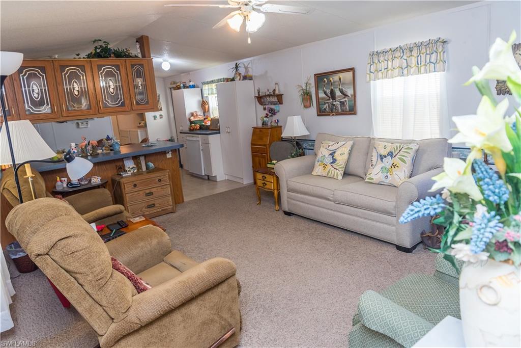 Living room featuring light colored carpet and ceiling fan