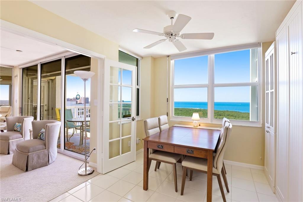 Dining space with a water view, a ceiling fan, and light tile patterned floors