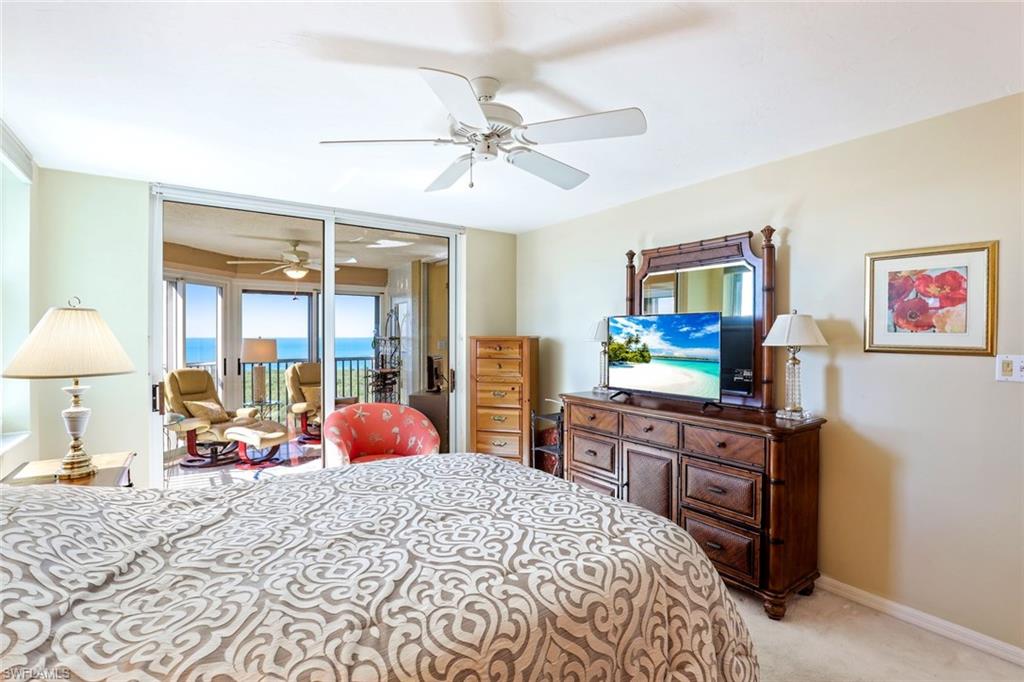 Bedroom with access to exterior, light colored carpet, and a ceiling fan