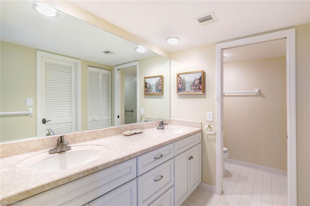 Full bath featuring a closet, double vanity, and light tile patterned floors
