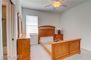 Bedroom with a ceiling fan and light colored carpet