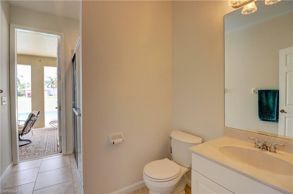 Full bathroom featuring vanity, light tile patterned flooring, and a shower with door