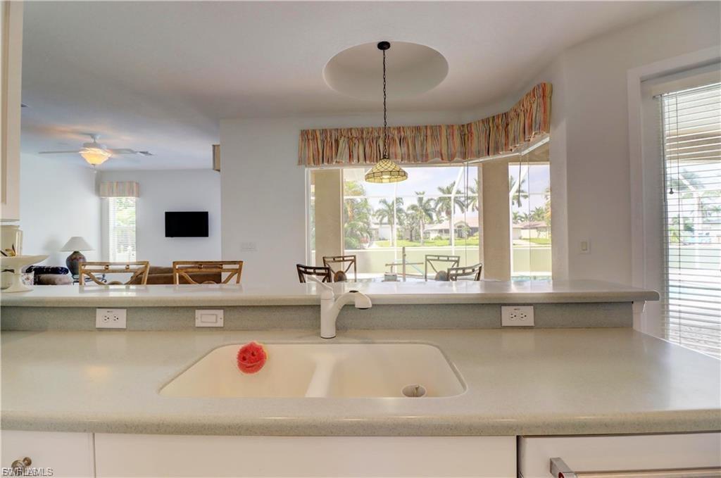 Kitchen featuring pendant lighting, open floor plan, ceiling fan, and a breakfast bar area