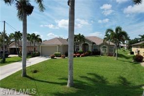 View of front of home featuring a front yard, driveway, and a garage