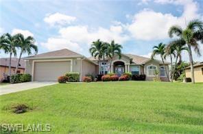 View of front of house with an attached garage, driveway, and a front lawn