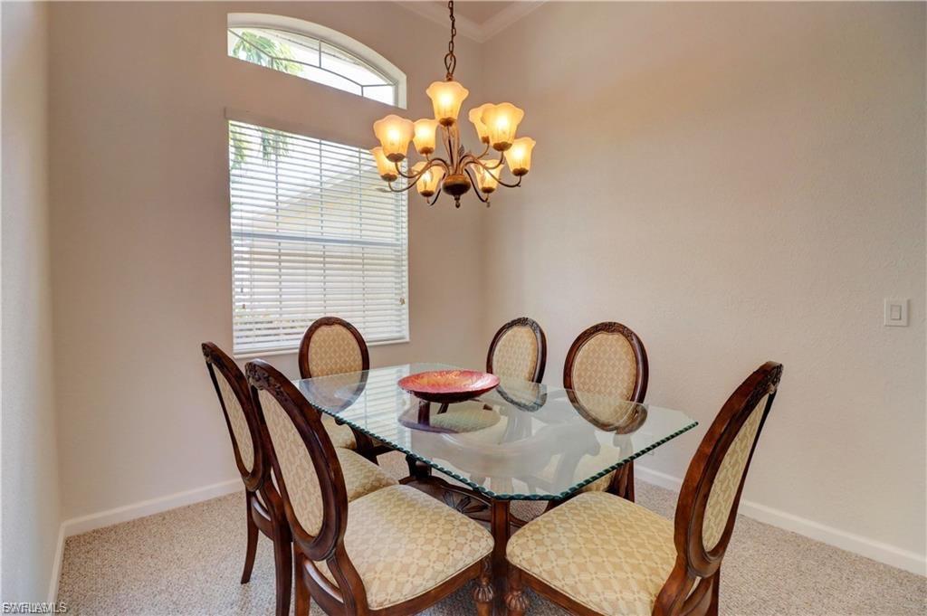 Dining room featuring hanging lights and light carpet