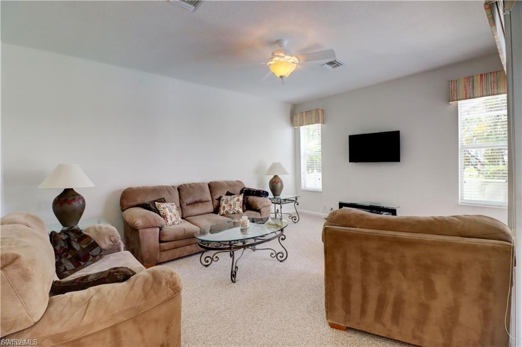 Carpeted living area with ceiling fan