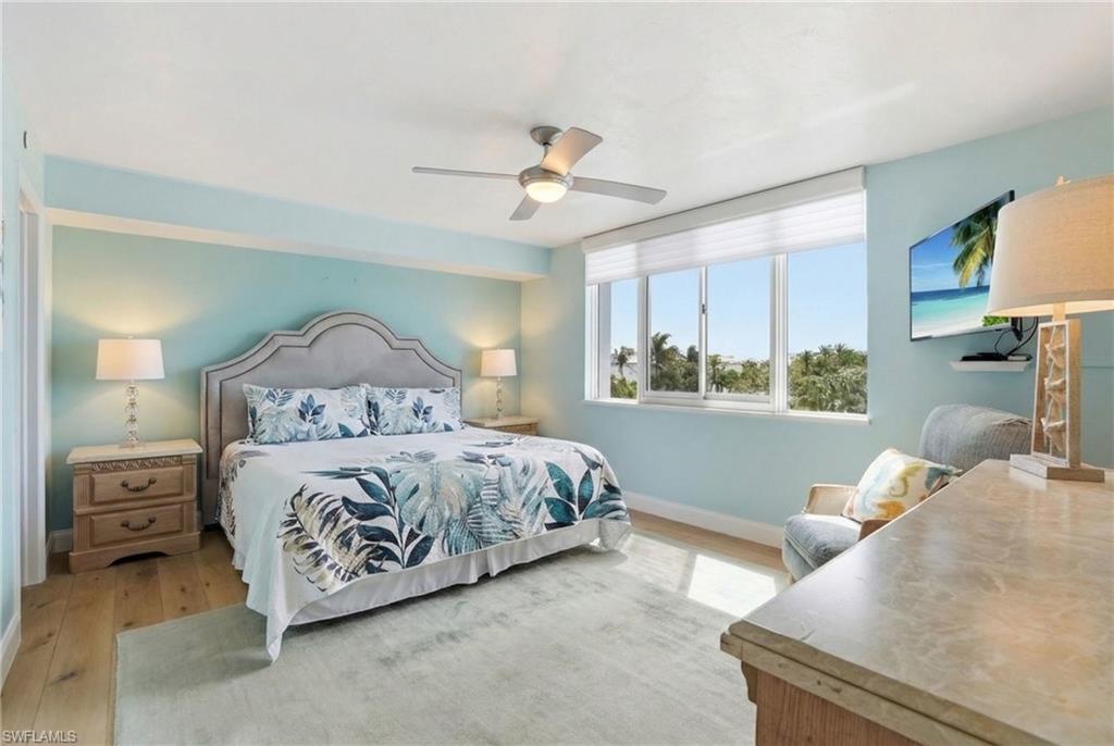 Bedroom featuring light wood finished floors and a ceiling fan - Virtually Edited Image