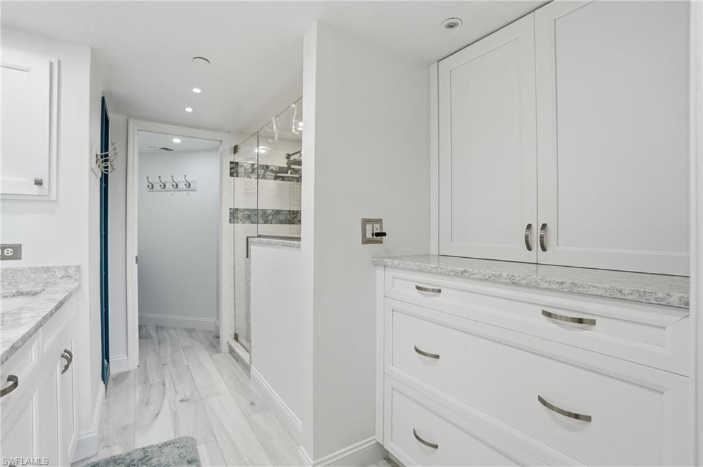 Full bathroom featuring vanity, a stall shower, recessed lighting, and light wood-type flooring - Virtually Edited Image