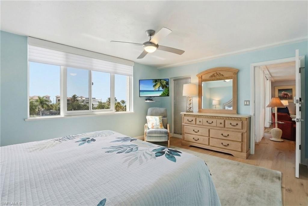 Bedroom featuring light wood-style floors and ceiling fan - Virtually Edited Image