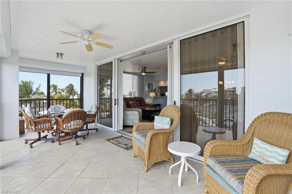 Sunroom / solarium with ceiling fan, a textured ceiling, and tile patterned flooring - Virtually Edited Image