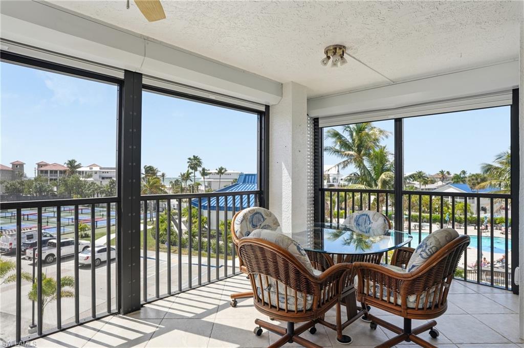 Sunroom featuring tile patterned flooring and a textured ceiling - Virtually Edited Image
