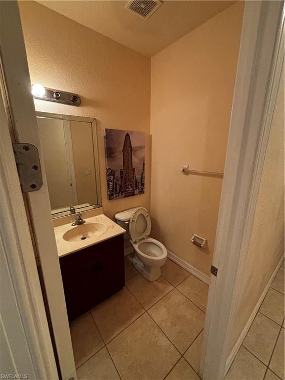 Bathroom featuring vanity, light tile patterned floors, and a textured wall