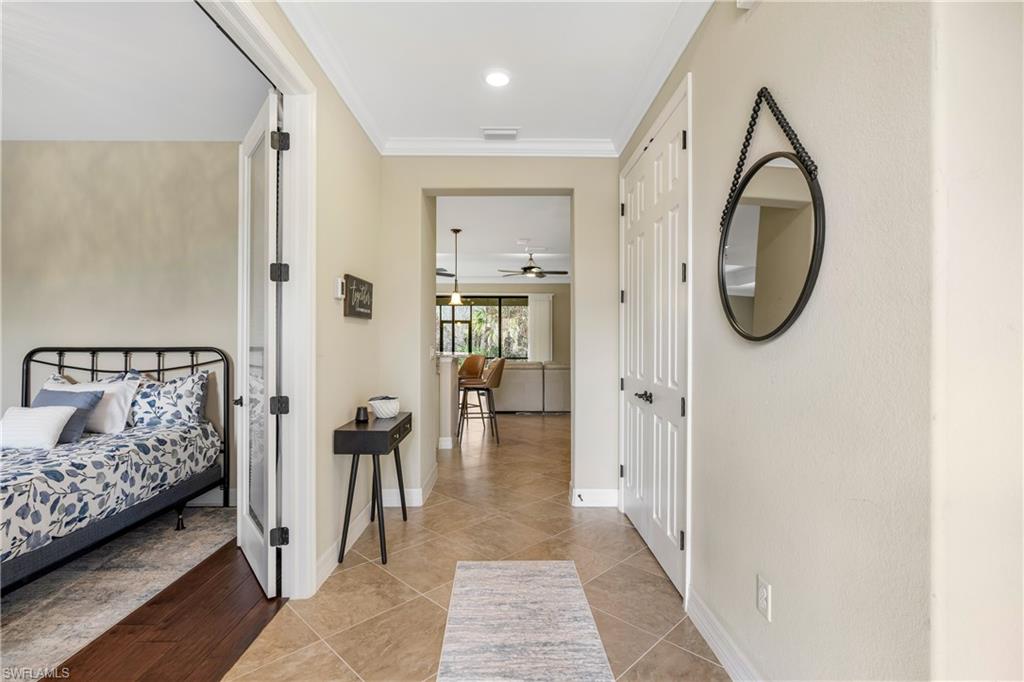 Hall with crown molding and light tile patterned floors