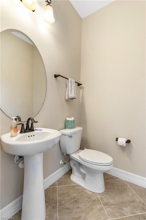 Bathroom with toilet and light tile patterned floors